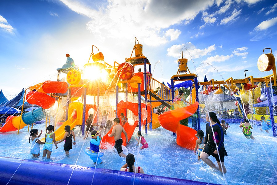 A vibrant water park in Dubai filled with children joyfully playing in the water under the sun