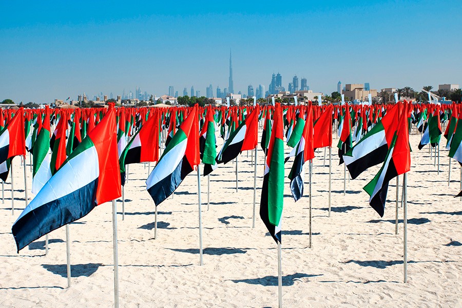 A vibrant display of flags fluttering on Kite Beach in Dubai, celebrating National Day with a festive atmosphere