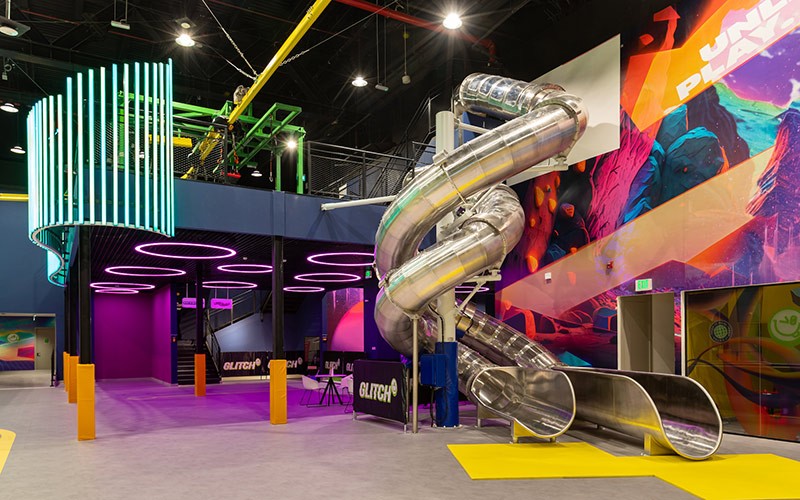 A vibrant indoor play area in Glitch Dubai featuring colorful walls and a fun slide for kids to enjoy