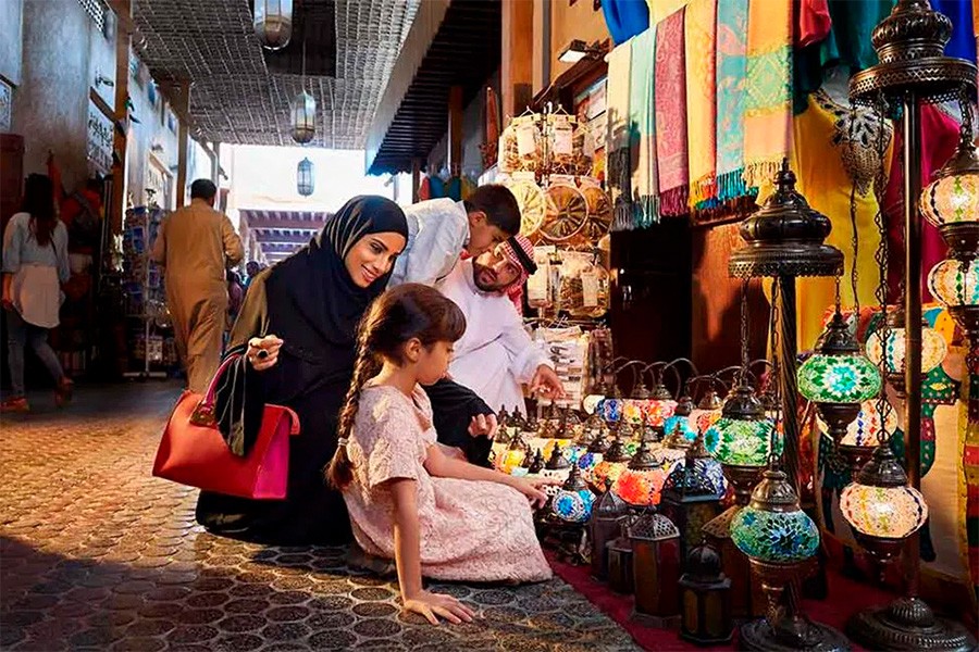 A woman and her dauhter admire various lamps in a lively market, free family activity