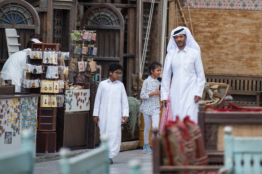 A father and his two children walk together along a vibrant street, things to do with Kids