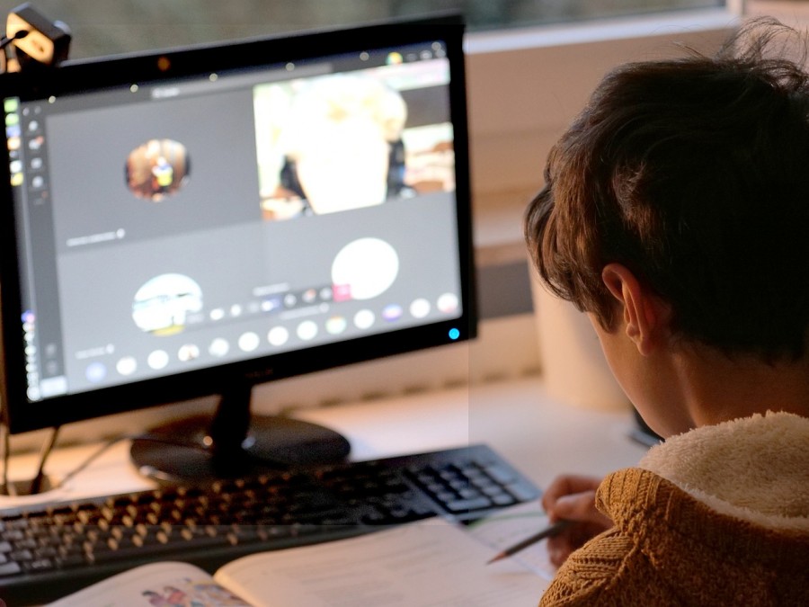 A boy focused on his laptop, learning and exploring with the help of a tutor for children