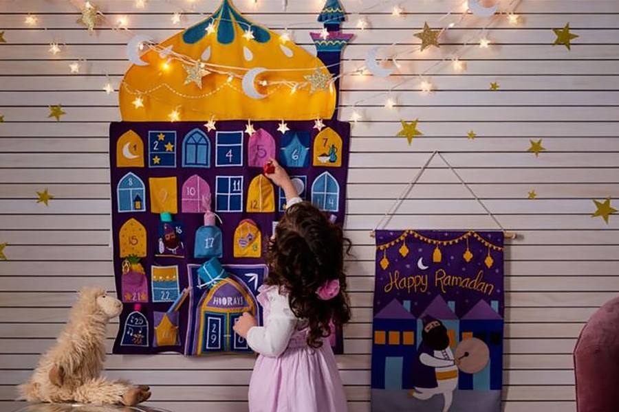 A girl observes a wall hanging illuminated with lights, symbolizing the spirit of giving during the Ramadan season