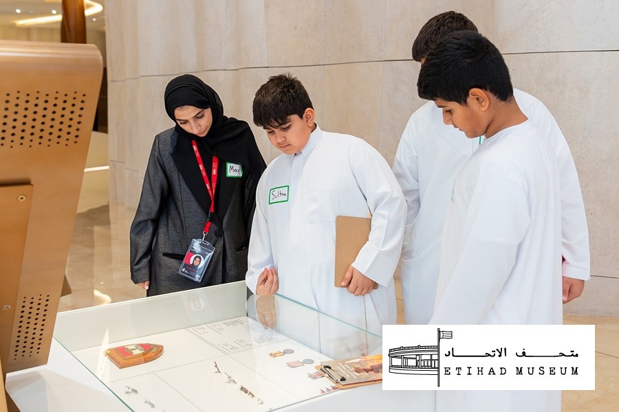 Four young people examining exhibits in a display case at a kid-friendly museum in Dubai