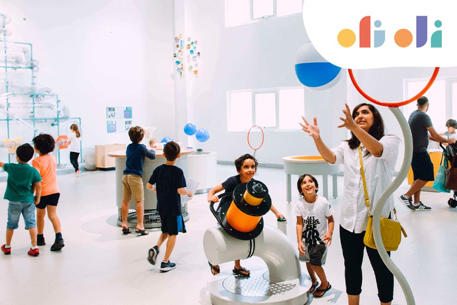 A group of children joyfully playing together inside a museum, exploring exhibits in a kid-friendly environment