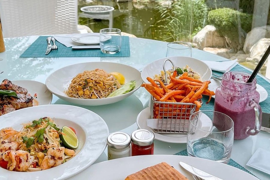 A beautifully set table at The Farm at Al Barari, featuring an array of plates filled with food and drinks