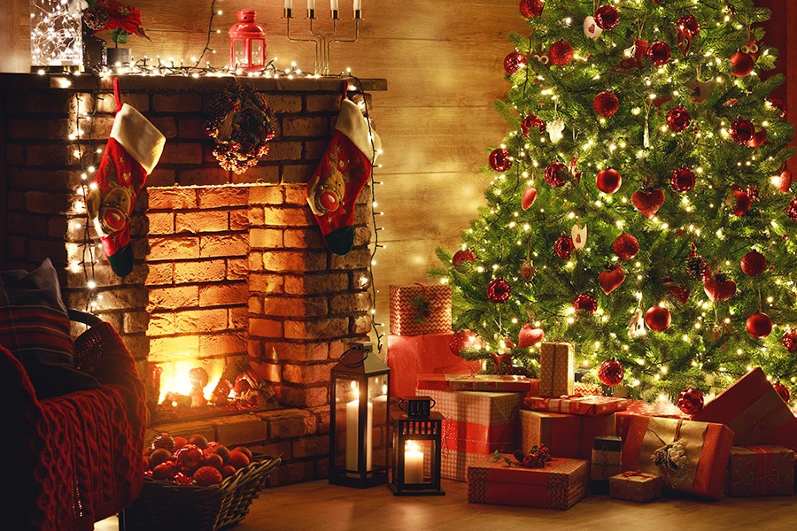 A cozy fireplace adorned with a Christmas tree and colorful presents, creating a magical holiday scene for kids in the UAE