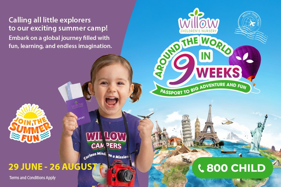 A cheerful child stands before a globe, highlighting summer camp opportunities for kids in Dubai